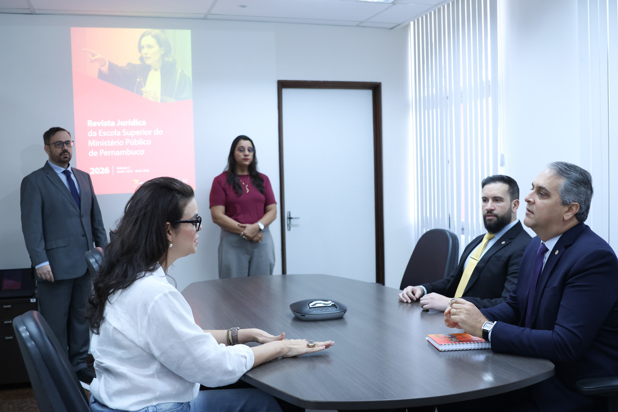 Fotografia dos participantes da reunião discutindo conteúdo da revista