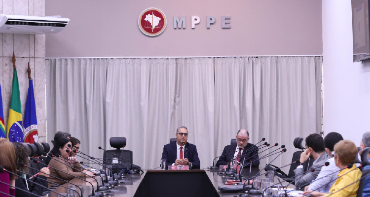 Fotografia dos participantes da reunião sentados em volta da mesa de discussões