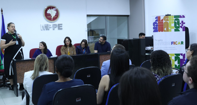 Fotografia de pessoas na plateia assistindo palestra