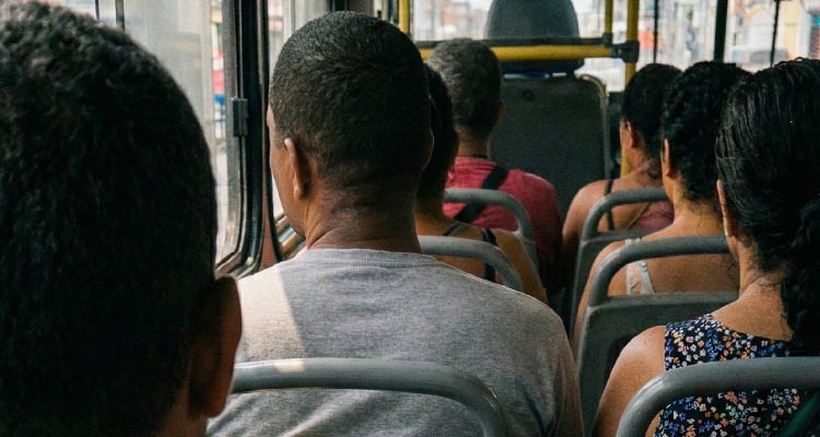 Fotografia de pessoas acomodadas em ônibus