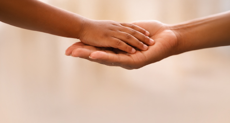 Imagem de mãos infantil e adulta se tocando