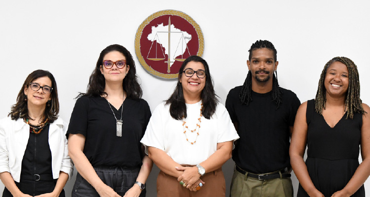 Fotografia de participantes da reunião posando em pé e lado a lado