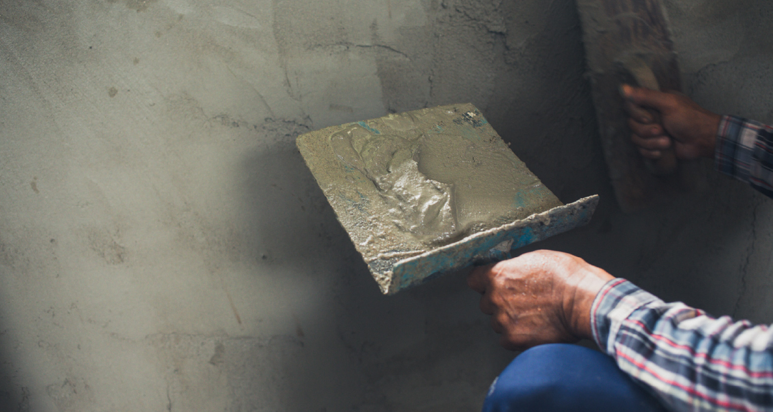 Imagem de homem rebocando parede