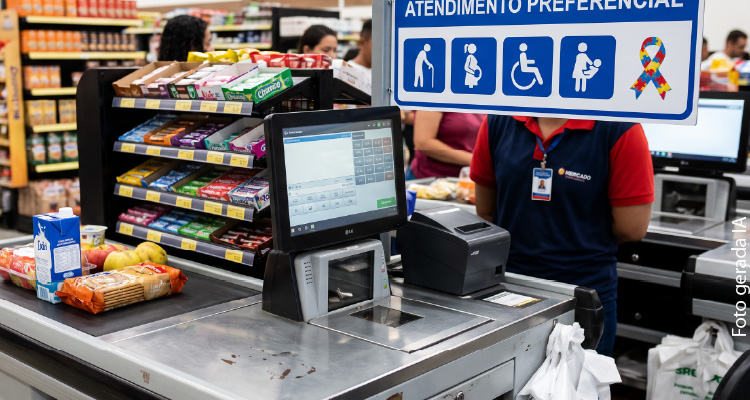 Imagem de fila do caixa de supermercado com aviso de preferência a pessoas com deficiência