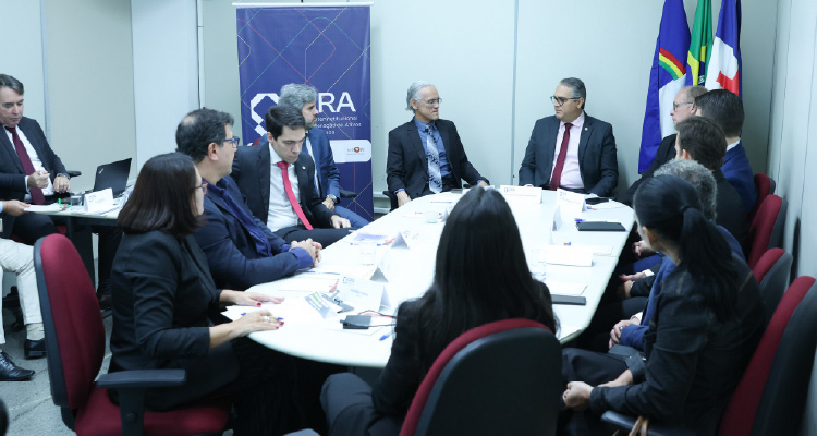 Fotografia da mesa de reunião com os representantes das instituições participantes